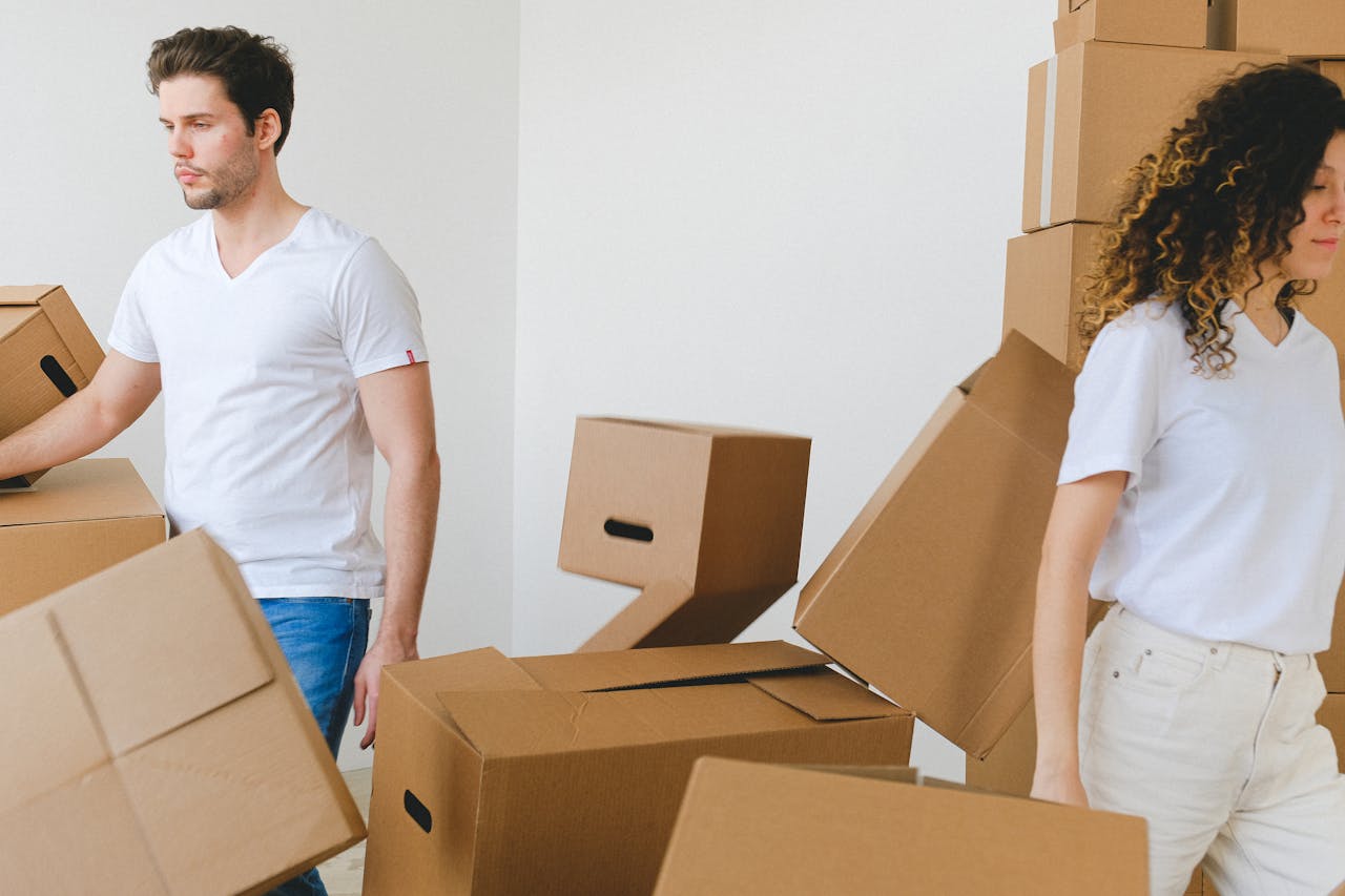Couple carrying boxes on moving day